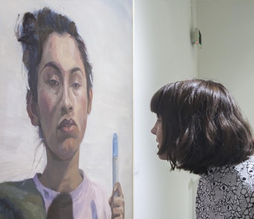 Student examining painted portrait