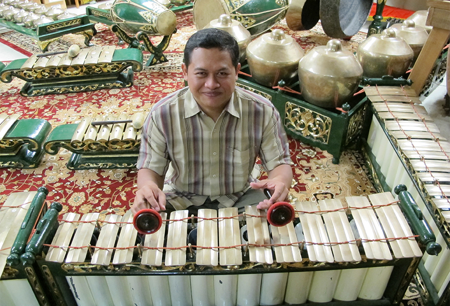 Person holding percussion instrument mallets in preparation to play a metallophone