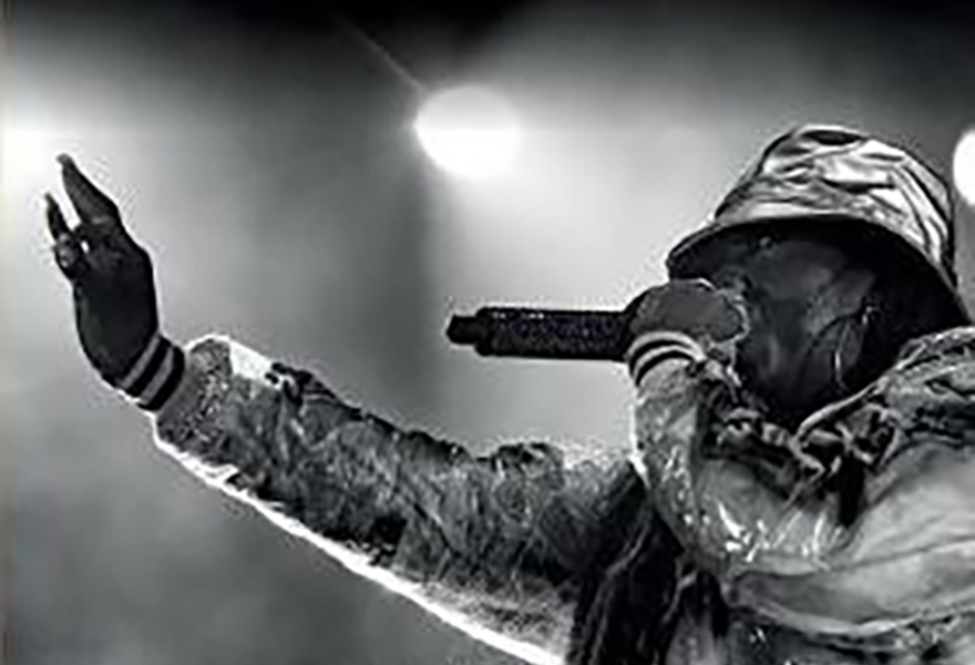 Person singing/rapping into a microphone on stage