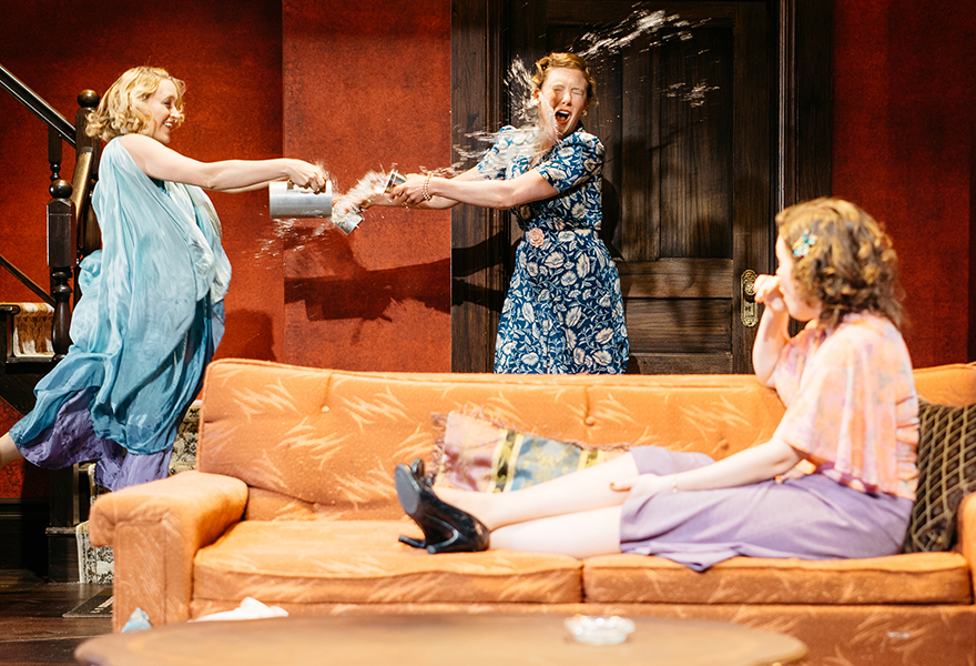 Performers throwing liquid at eachother on stage during a play