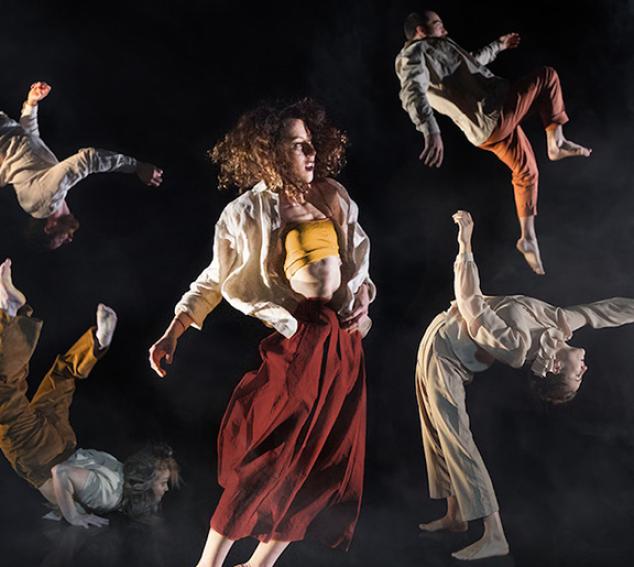 Five performers in aerial, acrobatic poses against a dark background