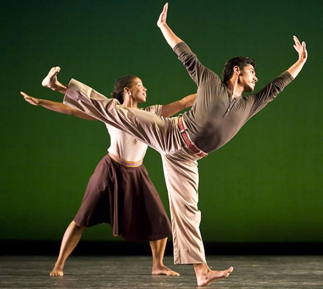 Two dancers, one male and one female, in action poses in front of a green background.