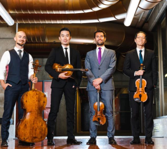 4 members of the Dover Quartet holding instruments